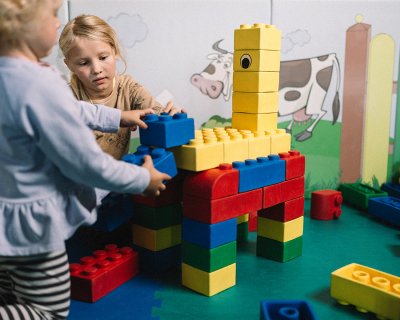 Kinder bauen bunte Giraffe aus großen Bausteinen