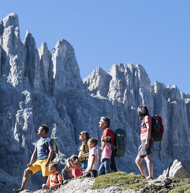 Familie beim Wandern vor schroffen Bergspitzen